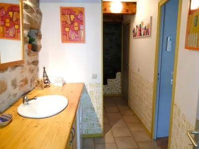 a bathroom with a sink and a wooden counter at Gîte des Orangers in Roquebrun