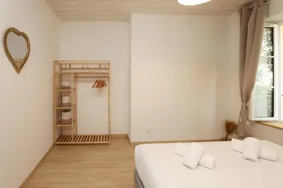 a white bedroom with a bed and a mirror at L impasse d'Anaïs Free Parking in Carcassonne