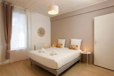 a bedroom with a white bed with two candles on it at L impasse d'Anaïs Free Parking in Carcassonne