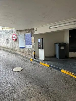 an empty parking garage with a sign on the wall at L impasse d'Anaïs Free Parking in Carcassonne