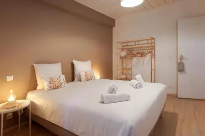 a bedroom with a large white bed with towels on it at L impasse d'Anaïs Free Parking in Carcassonne
