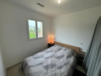 a bedroom with a bed with a lamp and a window at La Gourgotte in Ajac