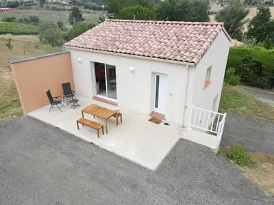 a small white house with a table and chairs at La Gourgotte in Ajac