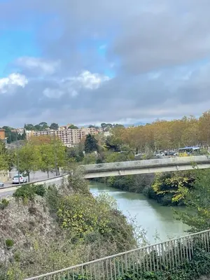 a bridge over a river next to a road at Chez Pauline & Vincent Côté Canal in Carcassonne