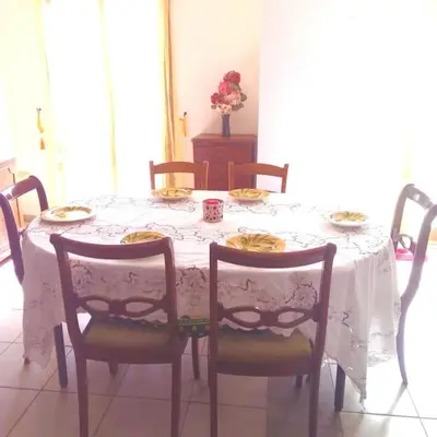 a dining room table with a white table cloth and chairs at Appartement du bonheur- 6 personnes in Gruissan