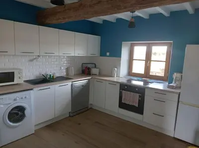 a kitchen with white cabinets and a washing machine at Maison indépendante à la ferme in Palleville