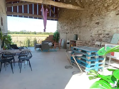 a room with tables and chairs and a brick wall at Maison indépendante à la ferme in Palleville
