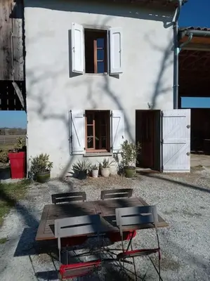 a table and chairs in front of a building at Maison indépendante à la ferme in Palleville