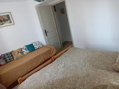 a small room with two beds and a door at Maison indépendante à la ferme in Palleville