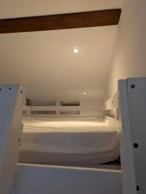 a white bed in a room with two doors at Studio indépendant tout équipé in Saint-Marcel