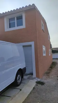 a white van parked in front of a brick building at Studio indépendant tout équipé in Saint-Marcel