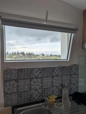 a window above a kitchen sink with a view at Studio indépendant tout équipé in Saint-Marcel