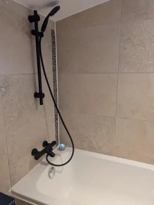 a shower in a bathroom with a black shower head at Studio indépendant tout équipé in Saint-Marcel