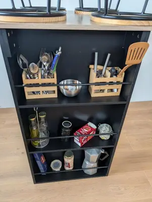 a kitchen shelf with utensils and other kitchen items at Studio indépendant tout équipé in Saint-Marcel