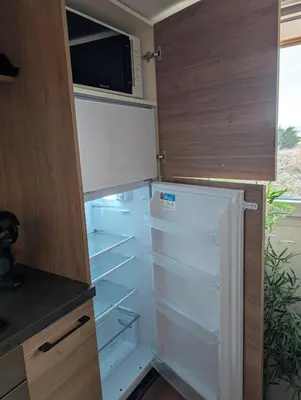 an empty refrigerator in a kitchen with a microwave at Studio indépendant tout équipé in Saint-Marcel
