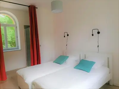 two white beds in a room with a window at Gîte de Las Cases 4 à 6 personnes in Lempaut