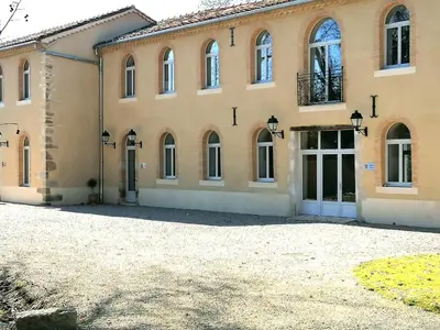 a large brick building with doors and windows at Gîte de Las Cases 4 à 6 personnes in Lempaut
