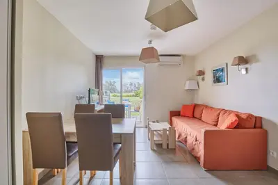 a living room with a couch and a table at Résidence Odalys Côté Canal in Sallèles-dʼAude