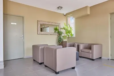 a waiting room with brown chairs and a mirror at Résidence Odalys Côté Canal in Sallèles-dʼAude