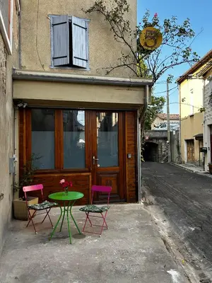 a table and four chairs in front of a building at Studio les Rosiers in Quillan