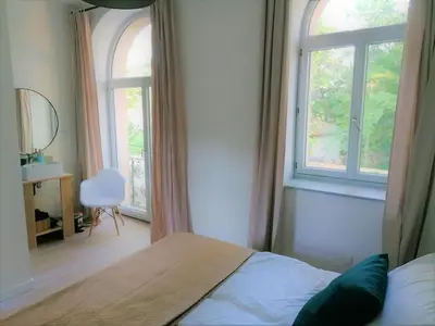 a bedroom with a bed and a large window at Gîte des Cisterciens 7 à 9 personnes in Lempaut