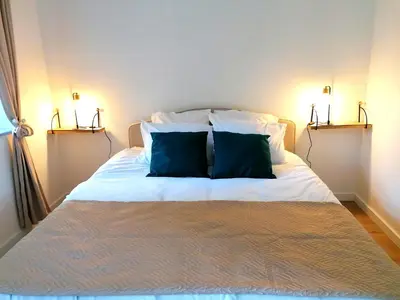 a bed with two blue pillows on top of it at Gîte des Cisterciens 7 à 9 personnes in Lempaut