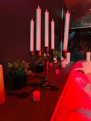a table with pink candles and red lights on it at La parenthèse Love room in Moussan