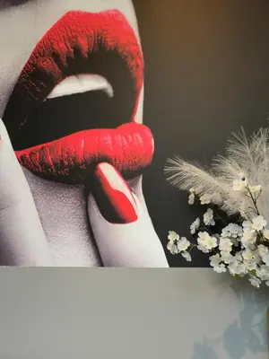 a woman with red lipstick on her legs with flowers at La parenthèse Love room in Moussan