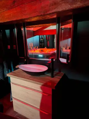 a bathroom with a red sink and a mirror at La parenthèse Love room in Moussan