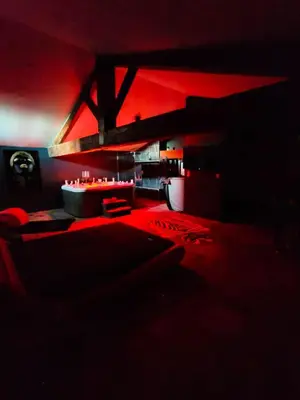 a red room with a bed and a table at La parenthèse Love room in Moussan