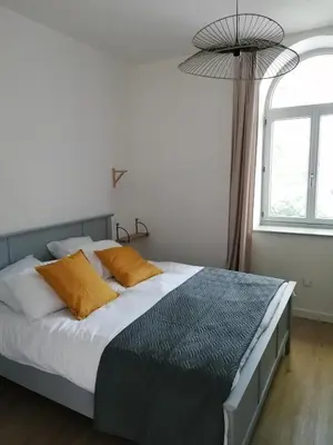 a bedroom with a large bed with orange pillows at Gîte des Cathares 2 personnes in Lempaut