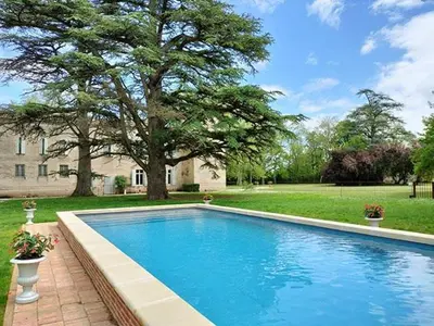 a swimming pool in front of a house with a tree at Gîte des Cathares 2 personnes in Lempaut