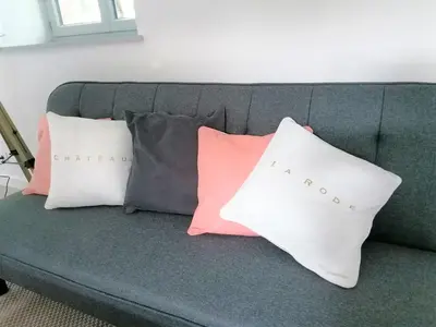 a gray couch with three pillows on it at Gîte des Cathares 2 personnes in Lempaut