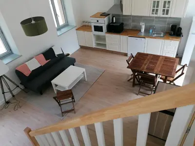 a living room and kitchen with a couch and a table at Gîte des Cathares 2 personnes in Lempaut