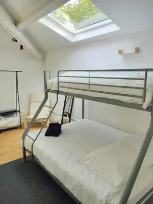 a bedroom with two bunk beds and a skylight at L'Orangerie 14 personnes in Lempaut