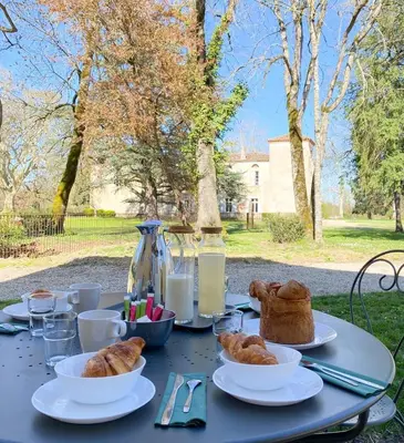 a table topped with plates of pastries and bread at L'Orangerie 14 personnes in Lempaut