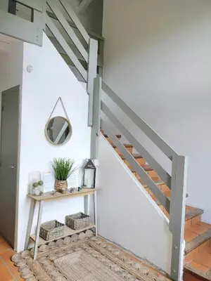 a staircase in a house with a table and a mirror at L'Orangerie 14 personnes in Lempaut