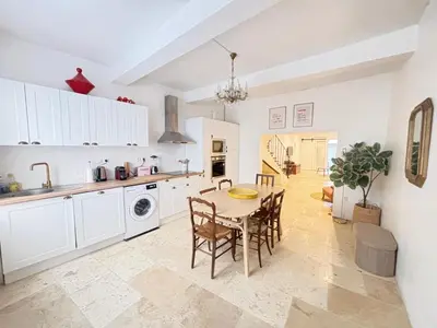 a kitchen and dining room with a table and chairs at Maison de Village - Standing - Centre Historique in Sigean
