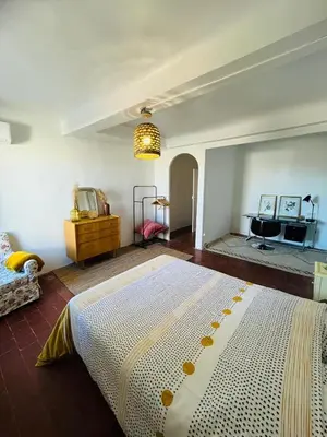 a bedroom with a large bed and a desk at Maison de Village - Standing - Centre Historique in Sigean