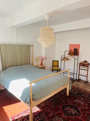 a bedroom with a bed and a chandelier at Maison de Village - Standing - Centre Historique in Sigean