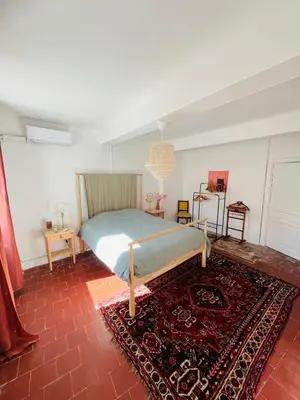 a bedroom with a bed and a rug at Maison de Village - Standing - Centre Historique in Sigean