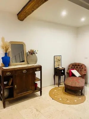 a room with a dresser with a mirror and a chair at Maison de Village - Standing - Centre Historique in Sigean
