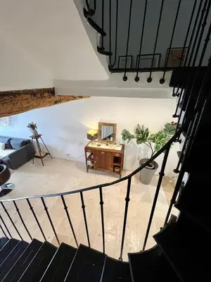 a stairway with a table and a mirror in a room at Maison de Village - Standing - Centre Historique in Sigean