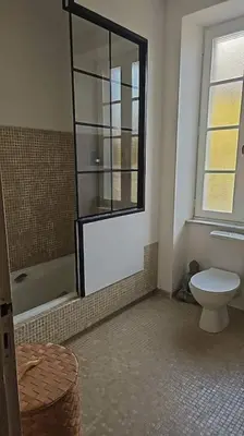 a bathroom with a toilet and a shower with a window at Hébergement - Canal du midi in Saint-Martin-Lalande