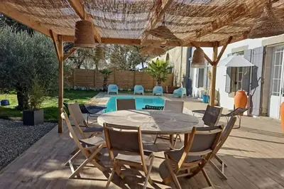 a patio with a table and chairs and a pool at Hébergement - Canal du midi in Saint-Martin-Lalande