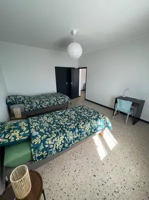 a room with two beds and a desk in it at Maison 2 chambres 3 lits 4 couchages et extérieur in Villefranche-de-Lauragais