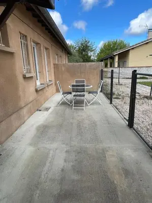 a patio with a table and chairs in front of a fence at Maison 2 chambres 3 lits 4 couchages et extérieur in Villefranche-de-Lauragais