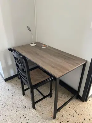a wooden table and a chair with a lamp on it at Maison 2 chambres 3 lits 4 couchages et extérieur in Villefranche-de-Lauragais