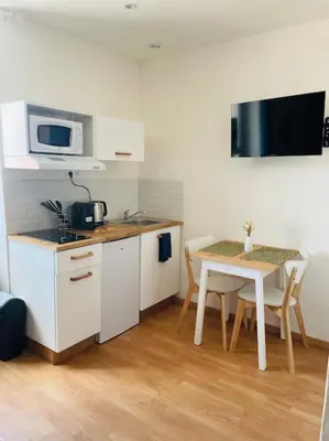 a small kitchen with a table and a microwave at Studio Charles de Gaulle V in Castres