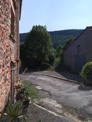 an empty road next to a brick building at maison dans village rural in Saint-Louis-et-Parahou